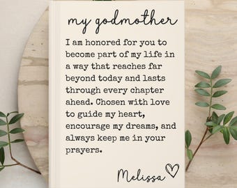 May include: A rectangular card with a cream background featuring black text that reads: my godmother. I am honored for you to become part of my life in a way that reaches far beyond today and lasts through every chapter ahead. Chosen with love to guide my heart, encourage my dreams, and always keep me in your prayers. Melissa with a heart symbol.