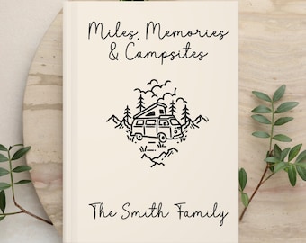May include: A cream-colored hardcover book featuring black line art of a camper van surrounded by trees and mountains. The text reads Miles, Memories & Campsites at the top and The Smith Family at the bottom in a simple black script font.