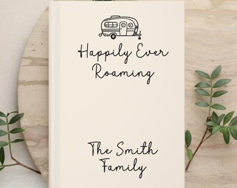 May include: A cream-colored hardcover book featuring a black line drawing of a vintage camper trailer at the top. Below the illustration, the text reads "Happily Ever Roaming" and "The Smith Family" in a simple black script font.