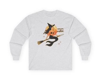 May include: A light gray long-sleeve shirt featuring a graphic of a mermaid witch wearing a black hat and riding a broomstick in front of a large orange moon. The text Salty witch is printed in black next to the illustration.