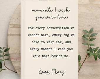 May include: A rectangular cream-colored card featuring black text that reads: moments I wish you were here. For every conversation we cannot have, every hug we have to wait for, and every moment I wish you were here beside me. Love, Macy.
