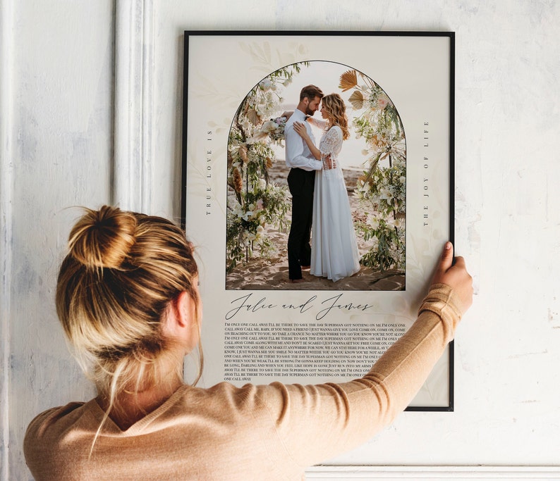 May include: A wedding photo print with a floral archway and the text "True love is the joy of your life" and "Jolie and James" printed below the photo.