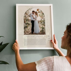 May include: A wedding photo print with a floral archway and the couple's names, "Jolie and James", and the date "20/11/22". The print has a white background with a floral pattern and the text "True Love Is The Joy Of Life".