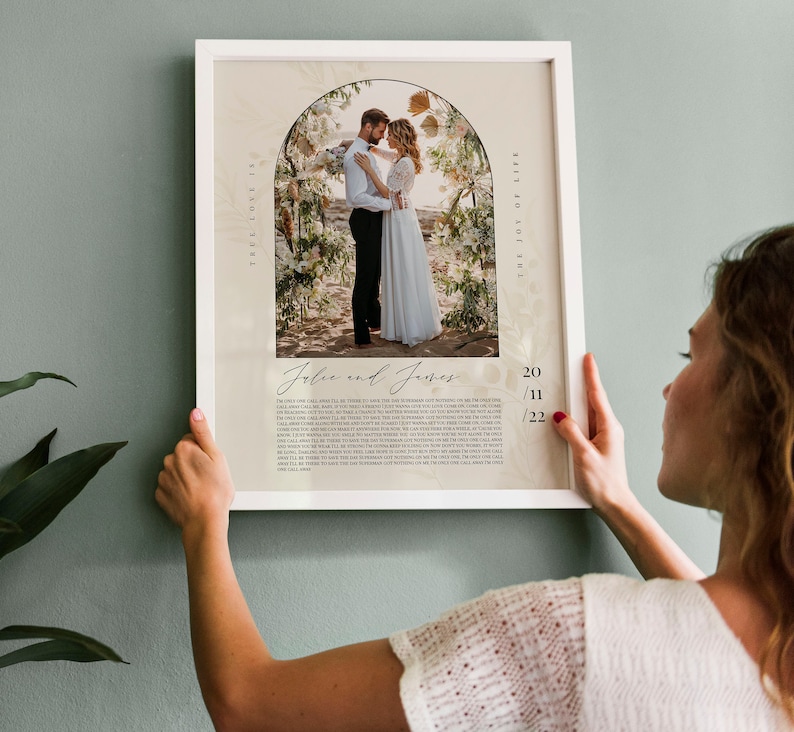 May include: A wedding photo print with a floral archway and the couple's names, "Jolie and James", and the date "20/11/22". The print has a white background with a floral pattern and the text "True Love Is The Joy Of Life".