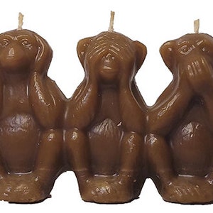 May include: Three brown monkey candles, each with one hand covering their eyes, ears, and mouth. The candles are arranged in a row, with the monkey covering its eyes on the left, the monkey covering its ears in the middle, and the monkey covering its mouth on the right.