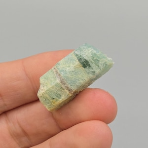 Aguamarina curvada con inclusiones verde oscuro y vetas minerales: ejemplar estructural único de Nigeria.