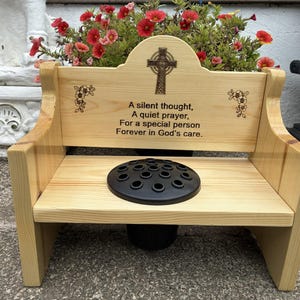 May include: A light-coloured wooden memorial bench featuring a Celtic cross engraving and the text: A silent thought, A quiet prayer, For a special person, Forever in God's care. The bench includes a black circular flower frog insert.