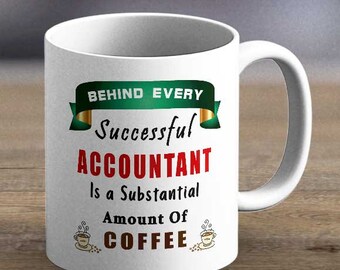 Op de afbeelding: Witte keramische koffiemok met een oor. De mok heeft de tekst "BEHIND EVERY Successful ACCOUNTANT Is a Substantial Amount Of COFFEE" in groen, rood en bruin. Twee kleine illustraties van koffiekopjes staan er ook op.