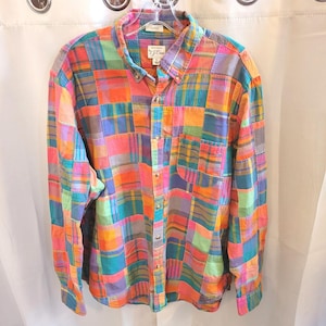 May include: A long-sleeve button-down shirt featuring a vibrant patchwork plaid pattern in shades of orange, pink, blue, green, and yellow. The shirt includes a front chest pocket, a standard collar, and a J.Crew brand label on the inner neck.