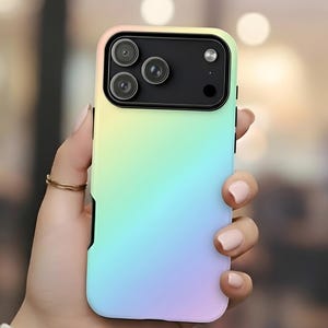 Puede incluir: Una funda de teléfono de color arcoíris pastel con un módulo de cámara negro se sostiene en una mano. La funda hace la transición de amarillo a azul, con un borde negro. La funda tiene tres lentes de cámara y un flash.