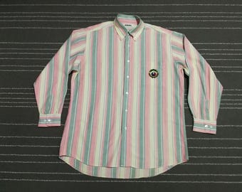 May include: A long-sleeved button-down shirt with pink, white, and green vertical stripes. The shirt has a small embroidered logo on the left chest.