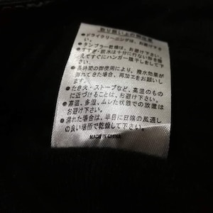 K&ouml;nnte beinhalten: Ein wei&szlig;es Pflegeetikett mit schwarzem Text in Japanisch, das Anweisungen zur Reinigung und Pflege des Kleidungsst&uuml;cks gibt. Der Text enth&auml;lt Informationen &uuml;ber chemische Reinigung, Trocknergeeignetheit, Sp&uuml;len und Trocknen. Er erw&auml;hnt auch, dass hohe Hitze und Lagerung in feuchter Umgebung zu vermeiden sind.