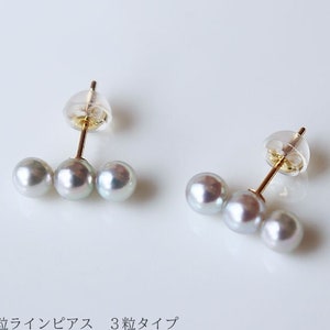 May include: A pair of pearl earrings with three pearls each. The earrings are made of 18 karat yellow gold or 14 karat white gold. The pearls are 4-5mm in size.