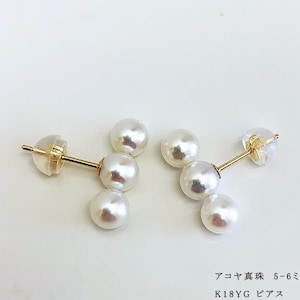 May include: A pair of gold earrings with a cluster of five white pearls. The earrings are in the shape of a small triangle. The text on the image reads "アコヤ真珠 5-6ミリ K18YG ピアス".