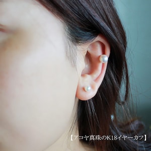May include: A close-up of a person's ear with two pearl earrings. The earrings are small and round, and they are made of white pearls. The earrings are set in a simple, elegant design.