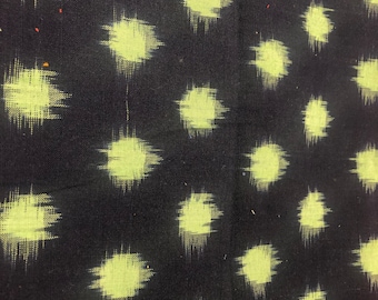 May include: Black fabric with a repeating pattern of light green, slightly blurred, circles.