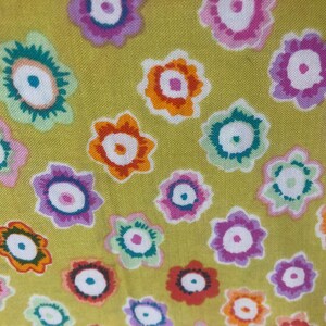 May include: A yellow fabric with a repeating pattern of colourful flowers. The flowers are in various shades of pink, red, orange, green, blue, and purple.