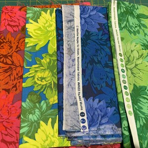 May include: Several fabric samples with large floral patterns in shades of red, orange, yellow, blue, and green. The fabric includes the text "Martha Negley for Rowan, Westminster Fabrics, #MN33 Packed Mums".