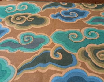 May include: A brown fabric with a repeating pattern of blue, green, and beige stylized clouds. The clouds have a swirling design.