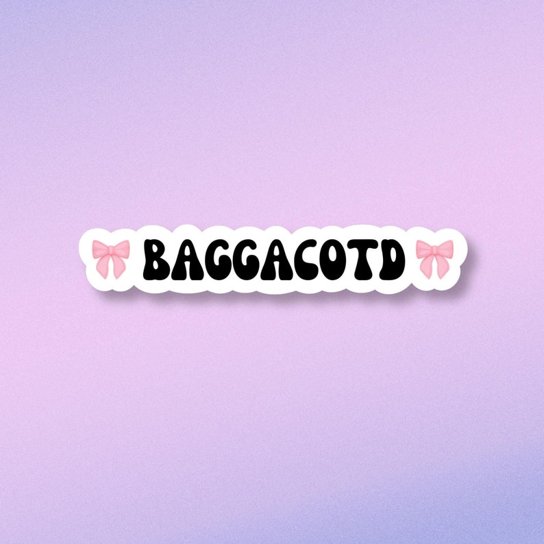 Op de afbeelding: Een witte sticker met zwarte tekst die "BAGGACOTD" zegt met roze strikken aan beide kanten.