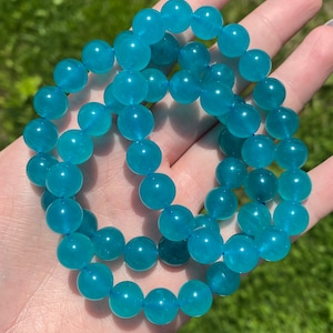 May include: A turquoise blue gemstone bracelet with round beads. The bracelet is made of natural stones and is a beautiful piece of jewellery.