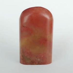 May include: A red and yellow stone seal with a rounded top and a rectangular base.