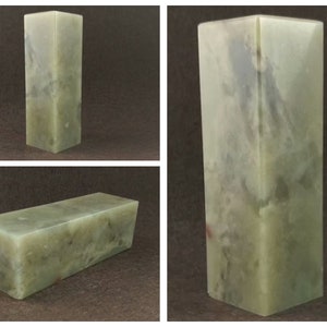 May include: A rectangular green stone inkstone with a mottled pattern. The stone is smooth and polished.