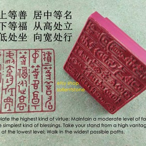 Puede incluir: Un sello rectangular rojo con caracteres tallados y una impresión estampada a juego. El sello tiene un borde biselado y está junto a un cuadrado estampado con columnas verticales de caracteres. También hay texto en inglés y chino.