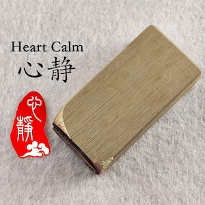 May include: A rectangular wooden stamp with the text "Heart Calm" and Chinese characters. A red stamp with white text and cloud design is also present. The stamp has a natural wood grain finish.