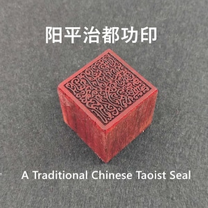 Puede incluir: Un sello de madera rojo, cuadrado, con intrincadas tallas en la superficie superior. El sello tiene caracteres chinos y el texto "A Traditional Chinese Taoist Seal".