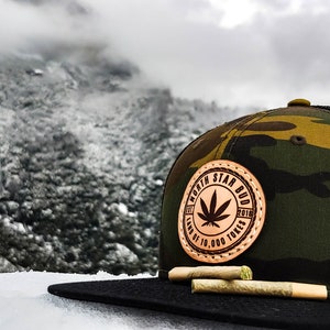 Minnesota Cannabis Leather Patch Woodland Camo Trucker Snapback Hat / North Star Bud
