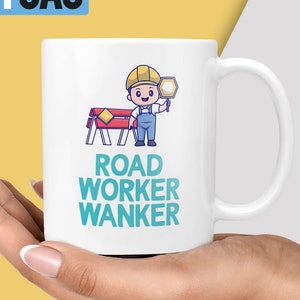 May include: White ceramic mug featuring a cartoon illustration of a road worker holding a stop sign. The text "ROAD WORKER WANKER" is printed in teal blue.