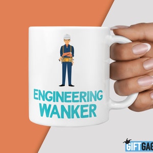 May include: White ceramic mug featuring a cartoon illustration of an engineer wearing a hard hat and tool belt. The text "ENGINEERING WANKER" is printed in blue on the mug.