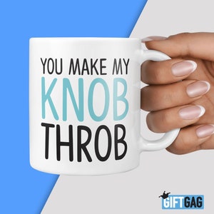 May include: White ceramic mug with black text that reads "You make my knob throb" in a playful, humorous font. The text "knob" is in light blue.