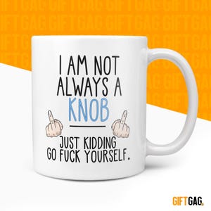May include: A white ceramic mug with a black handle and the text "But First, Coffee" in a black, bold font. The mug is on a white surface.