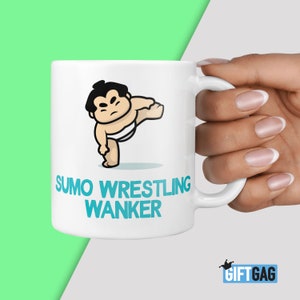 May include: White ceramic mug featuring a cartoon sumo wrestler illustration and the text "SUMO WRESTLING WANKER" in blue.