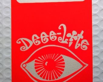 May include: A bright red sticker with a white eye design and the text "Deep 2 the" in a stylized font.