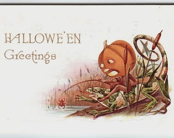May include: Vintage Halloween postcard featuring a pumpkin-headed figure fishing from a frog, with the words "HALLOWEEN Greetings" in elegant script. The illustration includes a spider and aquatic plants.