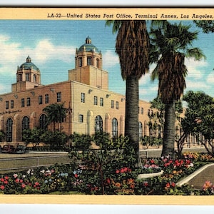 May include: A vintage postcard depicting the United States Post Office, Terminal Annex in Los Angeles, California. The building is a large, multi-story structure with a central tower and a flagpole flying the American flag. The building is surrounded by palm trees and lush greenery.