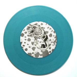 May include: A teal-colored vinyl record with a silver and black leopard design in the center. The leopard is detailed with a jeweled collar and the letter "A" is visible. The background of the center label has a spotted pattern.