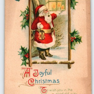 May include: A vintage Christmas postcard featuring a cartoon Santa Claus holding a lantern and looking out a window. The postcard has a holly border and the text "A Joyful Christmas To wish you in the ... good old way A bright and merry Christmas Day".