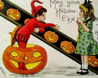 Pode incluir: Ilustração de cartão postal vintage de Halloween com um menino em uma fantasia de elfo vermelho emergindo de uma abóbora esculpida, estendendo a mão para uma menina em um vestido verde. A imagem inclui lanternas e o texto "May your Hallow-E'en."