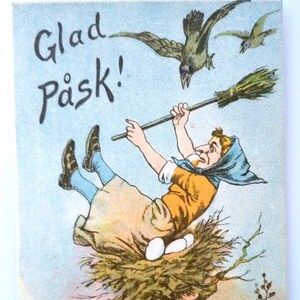May include: A vintage Easter card featuring a woman flying on a broomstick with a nest of eggs below her. The card has the text "Glad Påsk!" written in black.
