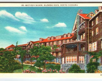 May include: Vintage postcard featuring Mayview Manor in Blowing Rock, North Carolina. The building has a brown facade, red roof, and multiple windows. The sky is blue with white clouds, and there are trees and flowers in the foreground.