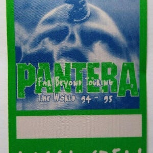 May include: Green and white Pantera "Far Beyond Touring The World 94-95" Local Crew pass. The pass features a blue and white skull graphic. The text "PANTERA" is in large green letters.