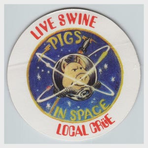 May include: A circular sticker featuring a central illustration of a pig wearing a space helmet against a blue starry background. The text reads LIVE SWINE PIGS IN SPACE LOCAL CRÜE in red and yellow lettering, with a small rocket ship graphic.