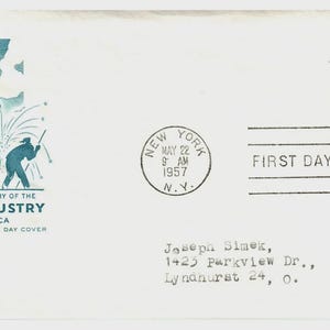 May include: A white envelope commemorating the 100th Anniversary of the Steel Industry of America. It features a teal illustration of steelworkers and a stamp with the text "America and Steel Growing Together." The envelope is postmarked May 22, 1957, in New York.