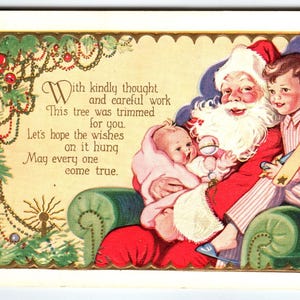 Carte postale Père Noël Saint-Nicolas assis tenant un bébé dans ses bras tandis qu'un garçon tient un avion jouet en relief