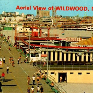 May include: A vintage postcard depicting an aerial view of Wildwood, N.J. The image shows a bustling boardwalk with people, shops, and amusement park rides. The text "Aerial View of WILDWOOD, N.J." is in red. The scene is rendered in warm, sunny colours.