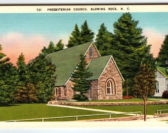 May include: Vintage postcard featuring the Presbyterian Church in Blowing Rock, N.C. The church, constructed of stone, has a green roof and arched windows. Lush green trees surround the building, with a grassy lawn and a white fence in the foreground.